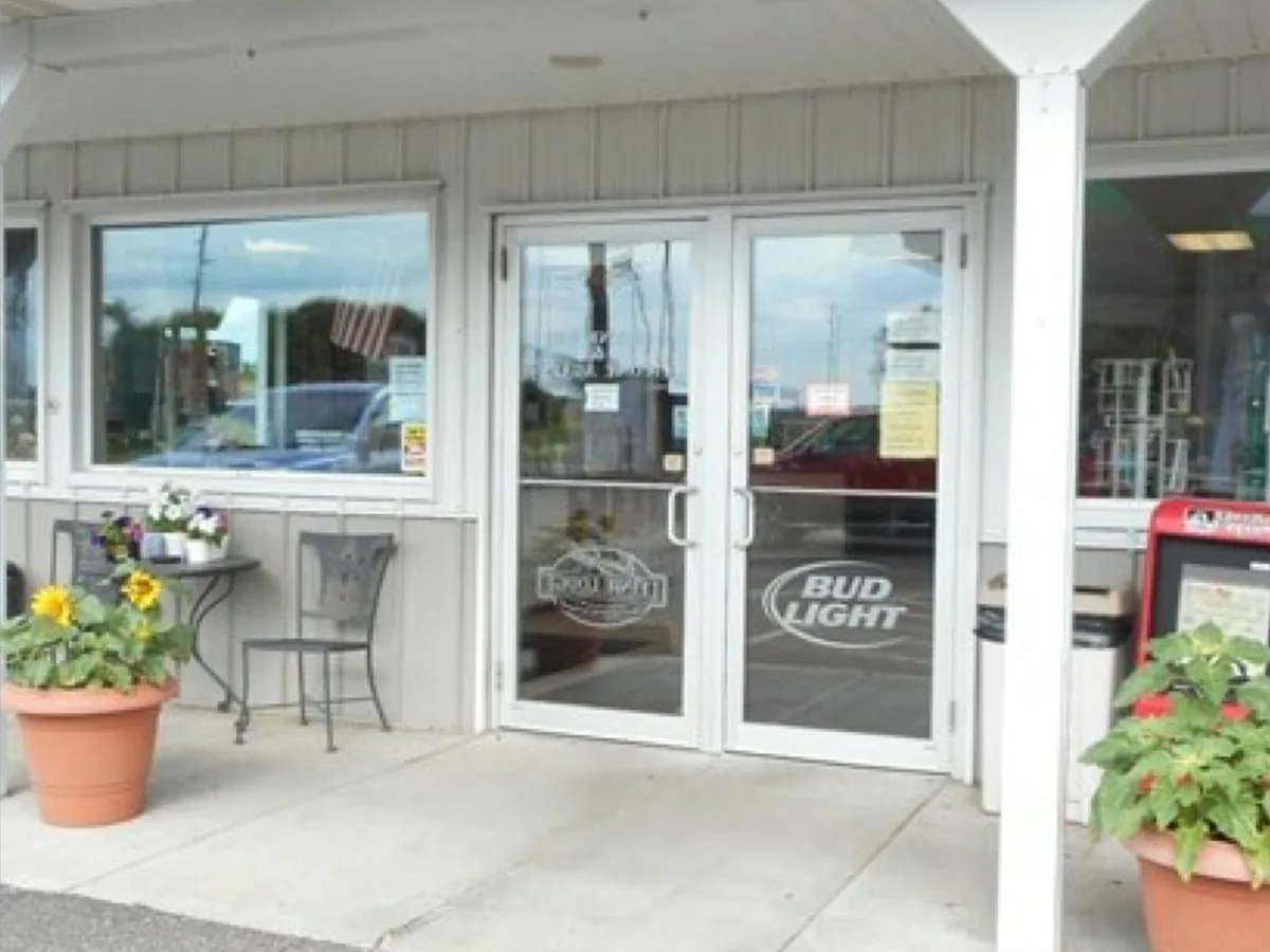 Restaurant entrance with glass double doors, patio seating and flower planters at N5696 850th St, Wisconsin